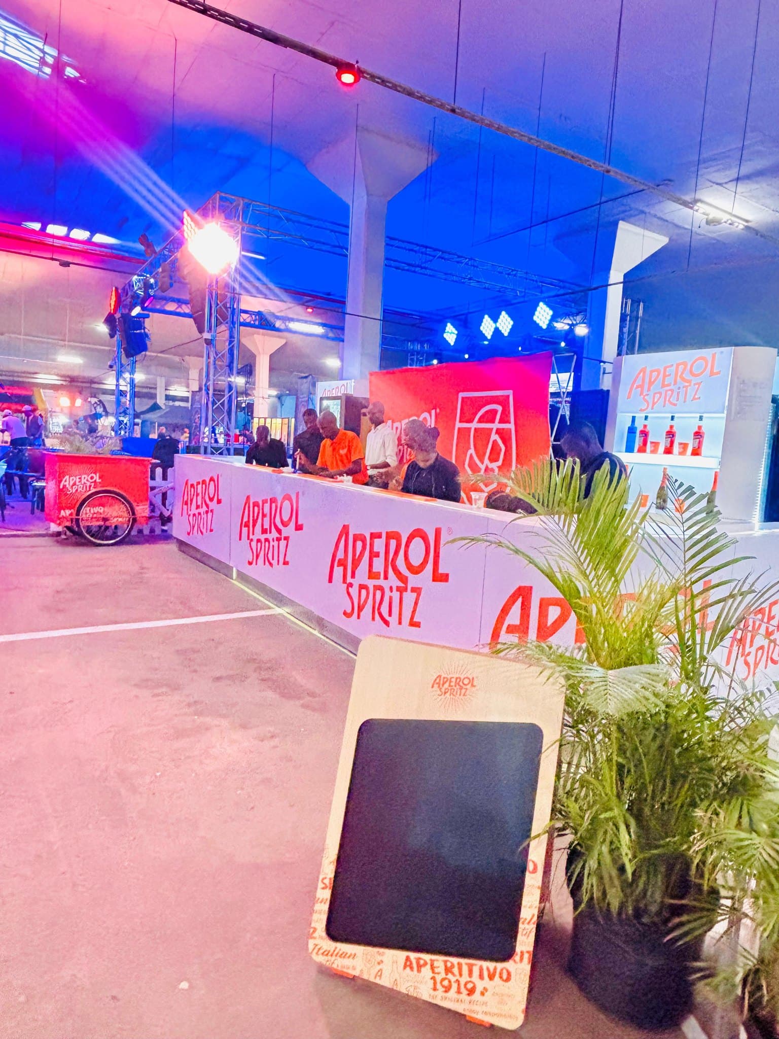 Aperol Spritz branded bar under blue and pink event lighting